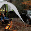 Couple close by campfire and awning