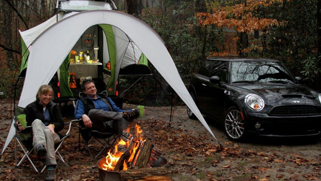 Couple close by campfire and awning