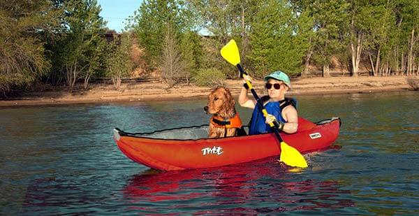 woman and dog inside kayak