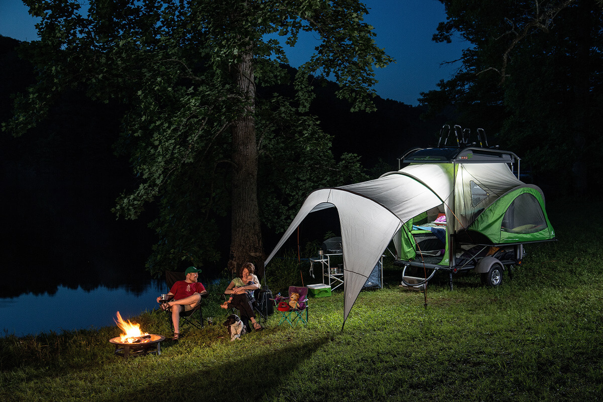 Couple sitting outside GO Camper during the night