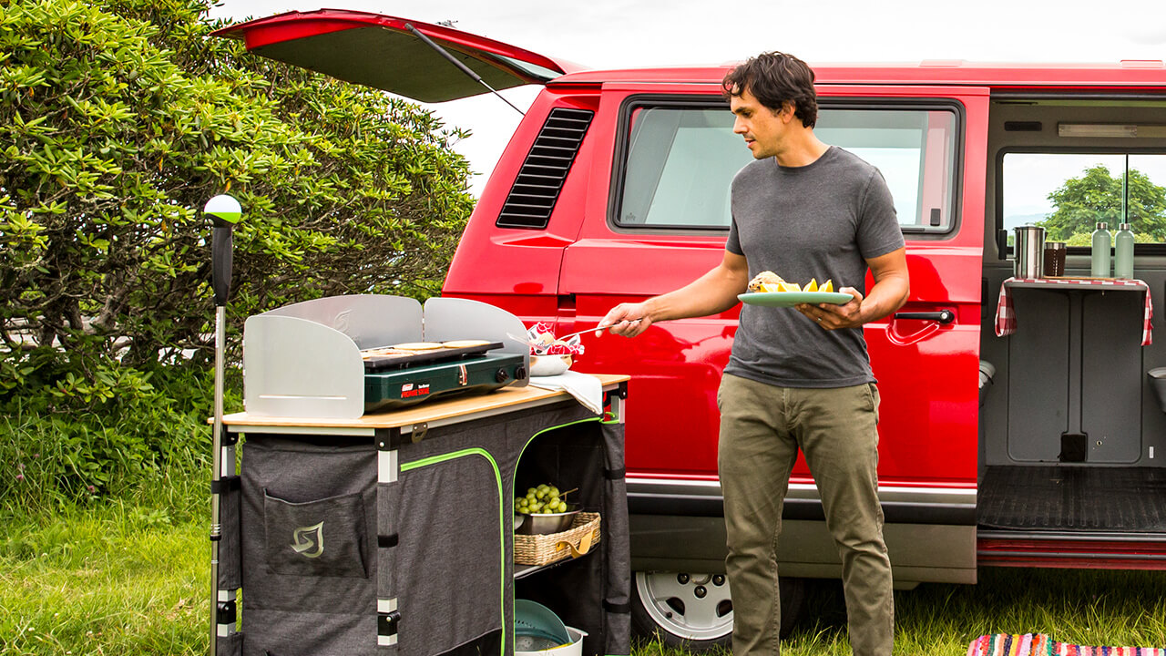 man cooking food on camp kitchen