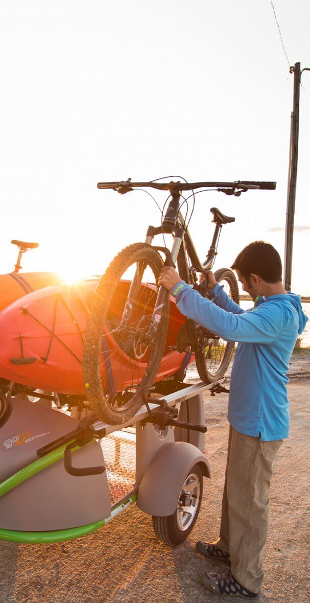 men unloading bike from kayak trailer