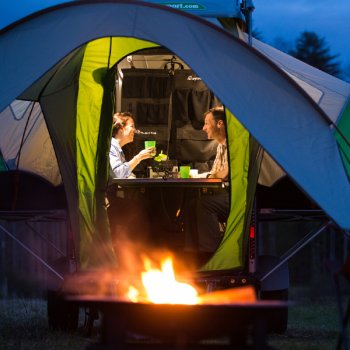 couple inside Go camper with fire pit outside