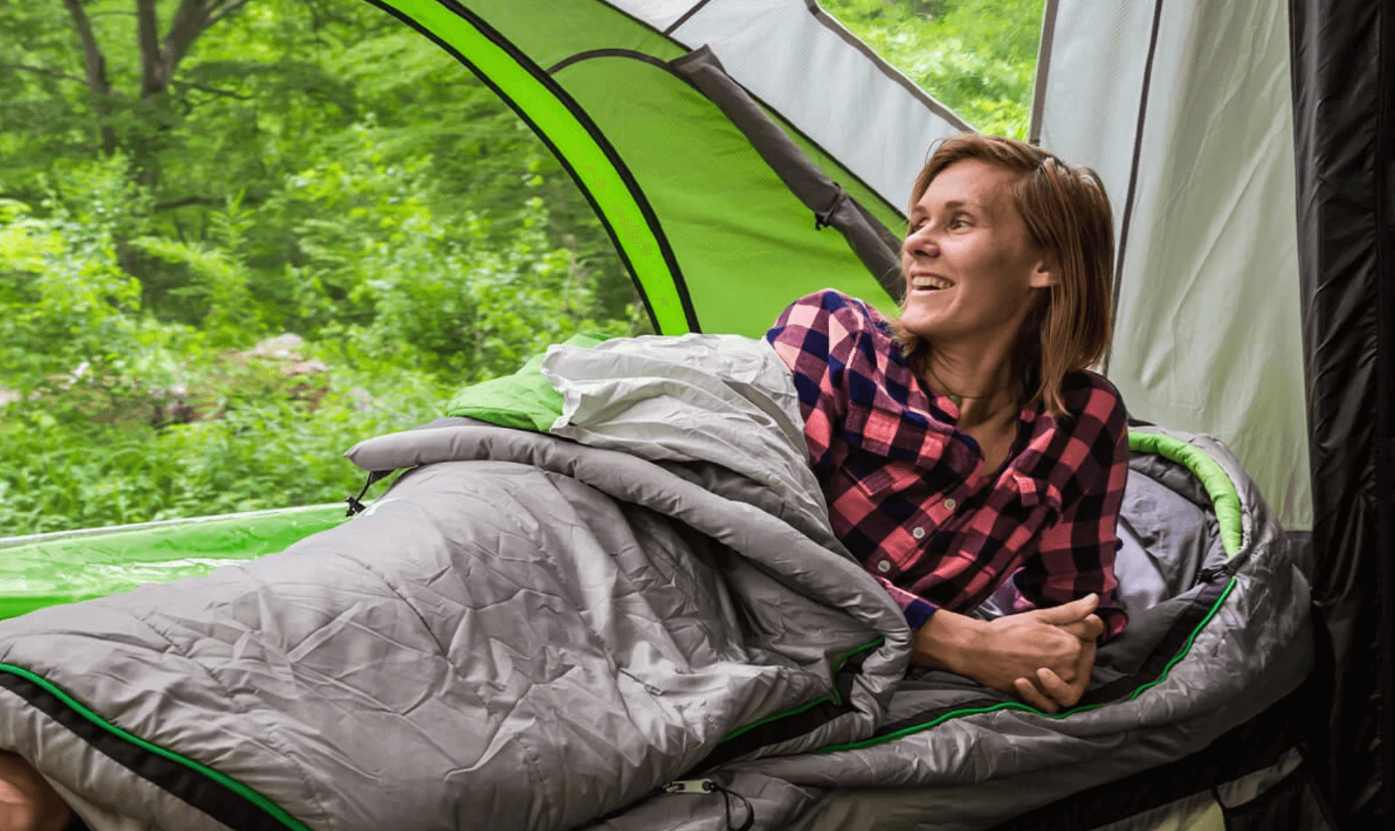 Woman laying down sleeping bag inside GO Camper