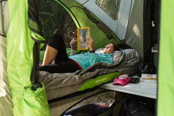 Woman reading mattress inside GO Camper