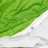 Close-up of green and white sleeping bag with snap buttons for outdoor camping.