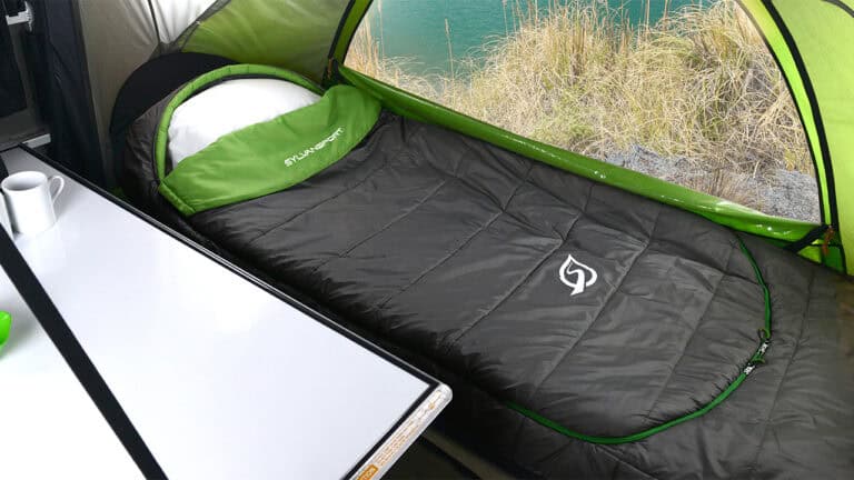 A comfortable sleeping area inside a SylvanSport camping tent with a green and black color scheme.