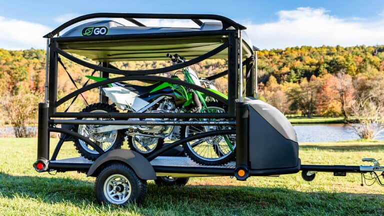 Compact SylvanSport GO trailer with motorcycle for outdoor adventures.