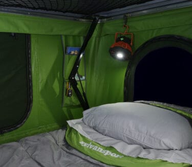 Optima camper interior with cozy sleeping area and efficient lighting.