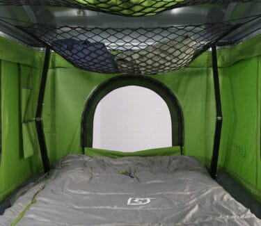 Optima camper interior with sleeping area and storage net.