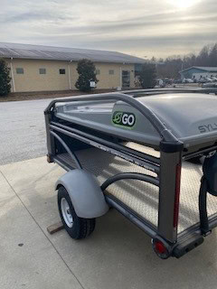 SylvanSport GO utility trailer with eco-friendly branding on a paved surface.