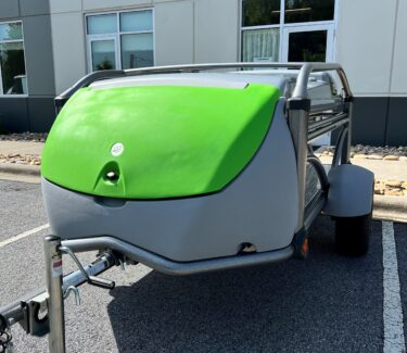 Compact SylvanSport Optima camping trailer with green and gray exterior for outdoor adventures.