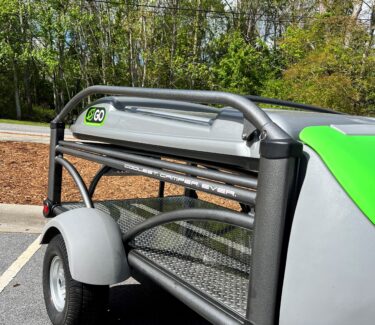 SylvanSport camping trailer with storage rack and green accents in outdoor setting.