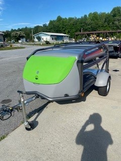Compact SylvanSport trailer with green and gray exterior parked outdoors.