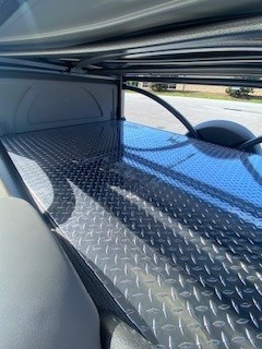 Interior view of SylvanSport utility trailer with diamond plate flooring.
