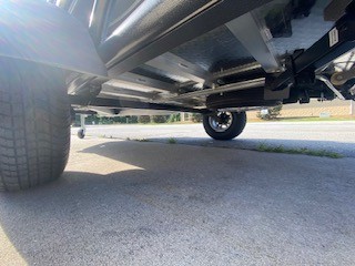 Close-up of SylvanSport utility trailer underside on pavement.