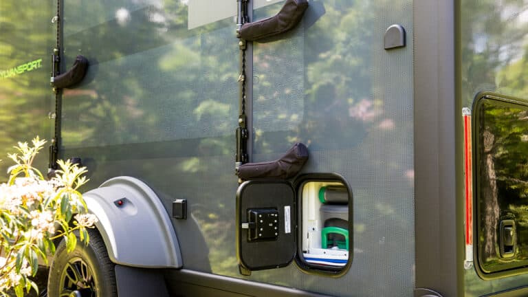 Close-up of SylvanSport VIRE travel trailer exterior with storage compartments and sleek design.