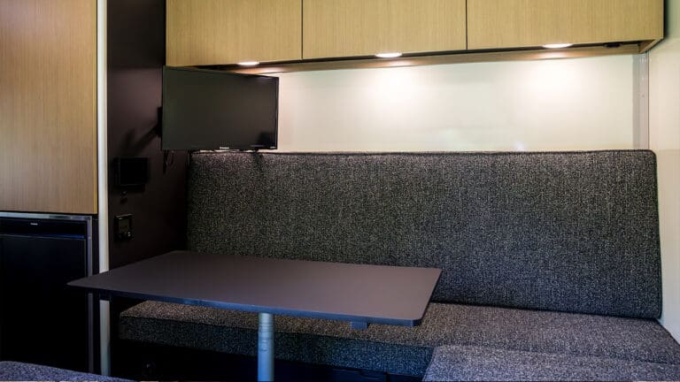 Interior of SylvanSport VIRE travel trailer with seating and table.
