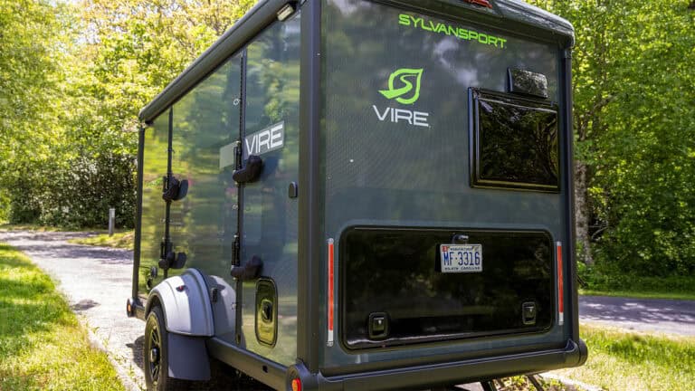 SylvanSport VIRE travel trailer parked in a lush green outdoor setting.