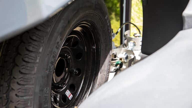 Close-up of a trailer wheel and suspension system for VIRE Travel Trailer.