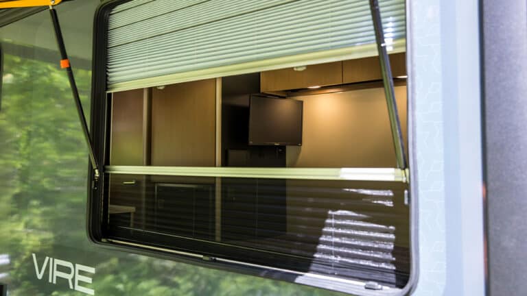 Interior view of VIRE Travel Trailer with modern kitchen and entertainment setup.