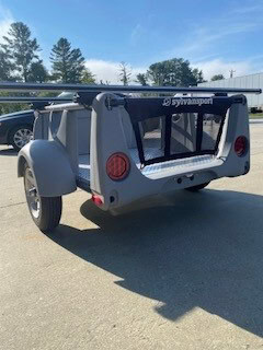 Compact SylvanSport adventure trailer with camping gear rack and rear door.