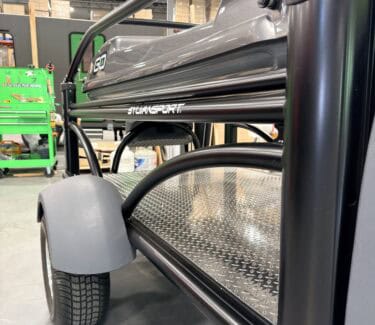 SylvanSport utility cart with black frame and metal platform in warehouse setting.