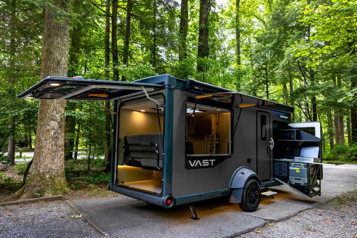 Vast travel trailer showing patented indoor/outdoor kitchen and large rear tailgate.