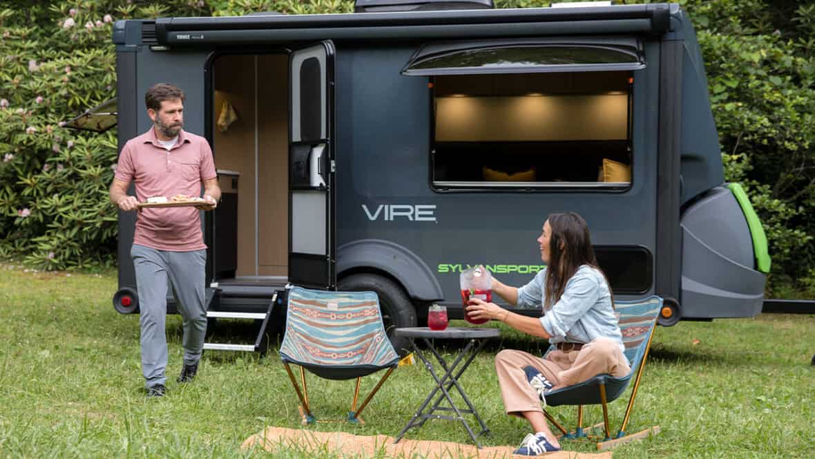 SylvanSport Vire camper trailer with outdoor setup and two people enjoying the outdoors.