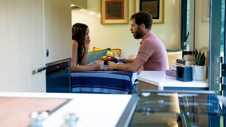 Couple having a conversation at a cozy indoor dining table.