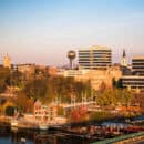 City skyline of Knoxville with buildings and a river in the foreground.